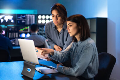 two female engineers working on laptop and review disaster recovery plan 